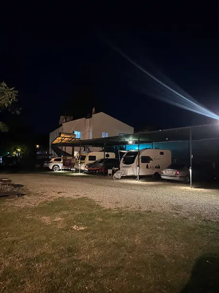 Abelya Camping karavan park alanı gece — tenteli gölgelik altında karavanlar, Marmaris Gökova karavan kamp alanı
